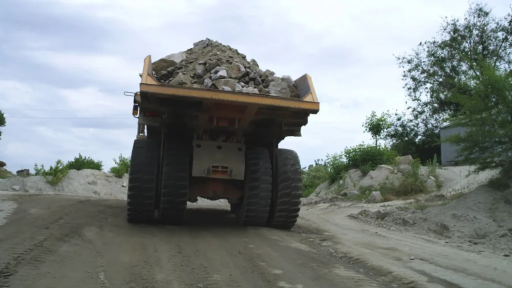 Home 3 tracking shot of truck with stone rubble driving on dirty road against cloudy sky on q SBI 351132012